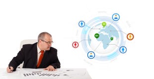 Geschäftsmann, der am Schreibtisch mit einer Kugel sitzt Lizenzfreies Stockfoto Geschäftsmann, der am Schreibtisch mit einer Kugel sitzt Lizenzfreies Stockfoto