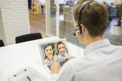 Geschäftsmann im Büro auf Videokonferenz mit Kopfhörer, Skype Stockfotos Geschäftsmann im Büro auf Videokonferenz mit Kopfhörer, Skype Stockfotos