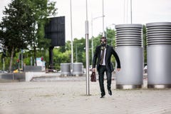 Geschäftsmannlaufen im Freien mit dem Aktenkoffer, der eine Gasmaske trägt stockbilder Geschäftsmannlaufen im Freien mit dem Aktenkoffer, der eine Gasmaske trägt stockbilder