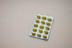 Gesloten omhoog gele tablet in blaarpak Capsules en pillen die in blaren worden ingepakt Geneesmiddel en gezondheidszorgconcept royalty-vrije stock fotografie Gesloten omhoog gele tablet in blaarpak Capsules en pillen die in blaren worden ingepakt Geneesmiddel en gezondheidszorgconcept royalty-vrije stock fotografie