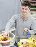 Gesunder Mann mit Einkaufenkorb kaufenden Früchten Stockbilder Gesunder Mann mit Einkaufenkorb kaufenden Früchten Stockbilder