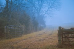 Gettysburg, PA/U.S.A. - dicembre 2018: Un vecchio recinto di legno lungo la strada non asfaltata mistica nella nebbia Concetto di immagini stock Gettysburg, PA/U.S.A. - dicembre 2018: Un vecchio recinto di legno lungo la strada non asfaltata mistica nella nebbia Concetto di immagini stock