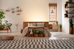 Gevormd tapijt voor bed in botanisch slaapkamerbinnenland met installaties en venster Echte foto stock afbeeldingen Gevormd tapijt voor bed in botanisch slaapkamerbinnenland met installaties en venster Echte foto stock afbeeldingen