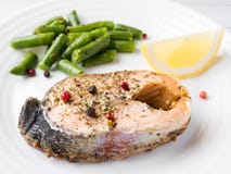 Gezond voedsel Gebakken rode vissen, roze zalm, zalm en slabonen met een plak van citroen op een plaat Stock Afbeelding Gezond voedsel Gebakken rode vissen, roze zalm, zalm en slabonen met een plak van citroen op een plaat Stock Afbeelding