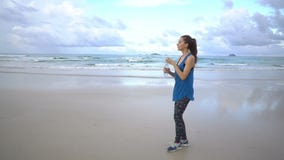 Gezonde actieve jonge vrouw die volgens kustlijn bij zonsopgang loopt Vrouwelijke Jogging stock footage Gezonde actieve jonge vrouw die volgens kustlijn bij zonsopgang loopt Vrouwelijke Jogging stock footage