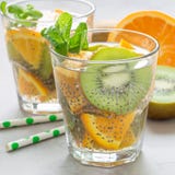 Gezonde het zaaddrank van detoxchia met kiwi, sinaasappel en munt in glas, vierkant formaat stock afbeelding Gezonde het zaaddrank van detoxchia met kiwi, sinaasappel en munt in glas, vierkant formaat stock afbeelding