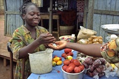 Ghanaian market woman sells vegetables and herbs