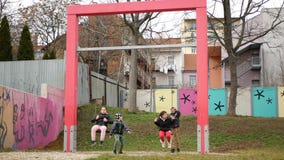 Ghetto poor in Brno, street life people children of gypsy play on swings
