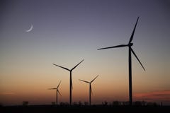Giacimento delle turbine dell'energia eolica di estate al tramonto fotografie stock Giacimento delle turbine dell'energia eolica di estate al tramonto fotografie stock