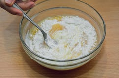 Giet de bloem in een glaskom met gebroken ei, het koken royalty-vrije stock foto Giet de bloem in een glaskom met gebroken ei, het koken royalty-vrije stock foto