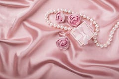 A gift box on a satin background is decorated with flowers and pearls. Flat layout stock images A gift box on a satin background is decorated with flowers and pearls. Flat layout stock images