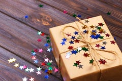 Gift box with star. Creative concept with festive decor on black background. Confetti stars, red, yellow with gift box. Explosion Stock Photography Gift box with star. Creative concept with festive decor on black background. Confetti stars, red, yellow with gift box. Explosion Stock Photography