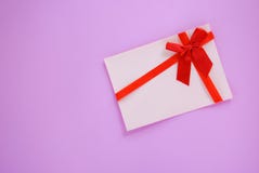 Gift card on red and pink background / Gift card decorated with red ribbon bow royalty free stock photography Gift card on red and pink background / Gift card decorated with red ribbon bow royalty free stock photography