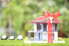 Gift new home and Real estate concept,Model house with Red ribbon on natural green background royalty free stock photos Gift new home and Real estate concept,Model house with Red ribbon on natural green background royalty free stock photos