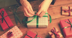 Gift wrapping. woman tie a green ribbon bow