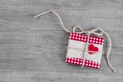 Giftbox обернуло в красной бумаге с красным сердцем для рождества Стоковые Изображения Giftbox обернуло в красной бумаге с красным сердцем для рождества Стоковые Изображения