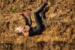 Gijón, Asturias, España - 4 de febrero de 2019 Rastro que funciona con al atleta de sexo femenino que cruza el charco sucio en ar imágenes de archivo libres de regalías Gijón, Asturias, España - 4 de febrero de 2019 Rastro que funciona con al atleta de sexo femenino que cruza el charco sucio en ar imágenes de archivo libres de regalías