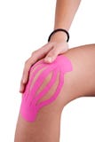 Ginocchio trattato con la terapia del nastro di kinesio fotografia stock libera da diritti Ginocchio trattato con la terapia del nastro di kinesio fotografia stock libera da diritti