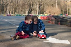 Gioco dei fratelli gemelli con un'automobile del giocattolo Fotografie Stock Libere da Diritti Gioco dei fratelli gemelli con un'automobile del giocattolo Fotografie Stock Libere da Diritti