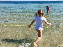 Gioco felice dei bambini allegro su una spiaggia in mare immagini stock libere da diritti Gioco felice dei bambini allegro su una spiaggia in mare immagini stock libere da diritti