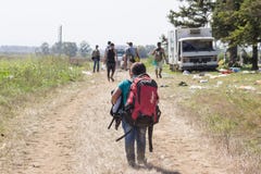 Giovane bambino del rifugiato che porta zaino pesante sul confine della Croazia Serbia, fra le città del Sid & Tovarnik sull'itin fotografia stock libera da diritti Giovane bambino del rifugiato che porta zaino pesante sul confine della Croazia Serbia, fra le città del Sid & Tovarnik sull'itin fotografia stock libera da diritti