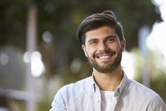 Giovane barbuto sorridente che si siede fuori, ritratto fotografia stock libera da diritti Giovane barbuto sorridente che si siede fuori, ritratto fotografia stock libera da diritti