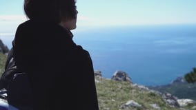 Giovane bella ragazza che cammina sopra la montagna sopra il mare video d archivio Giovane bella ragazza che cammina sopra la montagna sopra il mare video d archivio