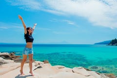 Giovane bella ragazza su una roccia vicino ad una costa di mare fotografia stock Giovane bella ragazza su una roccia vicino ad una costa di mare fotografia stock