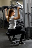 Giovane bicipite preparato della costruzione della ragazza in una palestra immagini stock Giovane bicipite preparato della costruzione della ragazza in una palestra immagini stock
