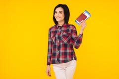 Giovane biglietto emozionante sorridente del passaggio di imbarco del passaporto della tenuta della studentessa isolato su fondo fotografia stock Giovane biglietto emozionante sorridente del passaggio di imbarco del passaporto della tenuta della studentessa isolato su fondo fotografia stock