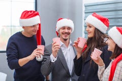 Giovane champagne della bevanda dei colleghi di affari sulla notte di Natale fotografie stock libere da diritti Giovane champagne della bevanda dei colleghi di affari sulla notte di Natale fotografie stock libere da diritti