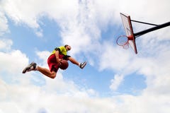 Giovane che fa una schiacciata fantastica che gioca pallacanestro immagine stock libera da diritti Giovane che fa una schiacciata fantastica che gioca pallacanestro immagine stock libera da diritti