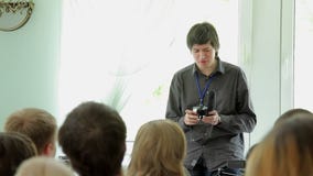 Giovane che parla nella classe con sul microfono del fucile da caccia della macchina fotografica in mani archivi video Giovane che parla nella classe con sul microfono del fucile da caccia della macchina fotografica in mani archivi video