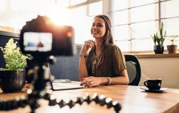 Giovane contenuto femminile della registrazione del vlogger per il suo video blog fotografia stock Giovane contenuto femminile della registrazione del vlogger per il suo video blog fotografia stock