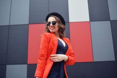 Giovane donna adorabile sveglia in occhiali da sole, rivestimento rosso, cappello di modo, controllante fondo astratto all'aperto immagini stock libere da diritti Giovane donna adorabile sveglia in occhiali da sole, rivestimento rosso, cappello di modo, controllante fondo astratto all'aperto immagini stock libere da diritti