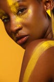 Giovane donna africana allegra con trucco giallo della molla su lei occhi Risata di modello femminile contro l'estate gialla fotografia stock libera da diritti Giovane donna africana allegra con trucco giallo della molla su lei occhi Risata di modello femminile contro l'estate gialla fotografia stock libera da diritti