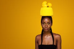 Giovane donna africana allegra con trucco giallo su lei occhi Modello femminile contro fondo giallo con i limoni gialli fotografie stock Giovane donna africana allegra con trucco giallo su lei occhi Modello femminile contro fondo giallo con i limoni gialli fotografie stock