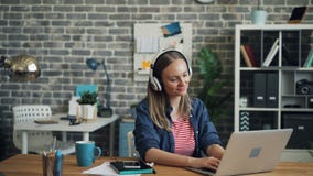 Giovane donna attraente che ascolta la musica tramite le cuffie che ballano sul lavoro stock footage Giovane donna attraente che ascolta la musica tramite le cuffie che ballano sul lavoro stock footage