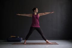 Giovane donna attraente che risolve all'interno fare esercizio di yoga immagine stock Giovane donna attraente che risolve all'interno fare esercizio di yoga immagine stock