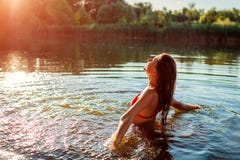 Giovane donna in bikini che gioca in acqua e che fa spruzzata Vacanza di estate immagini stock libere da diritti Giovane donna in bikini che gioca in acqua e che fa spruzzata Vacanza di estate immagini stock libere da diritti