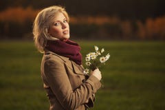 Giovane donna bionda felice di modo che indossa camminata beige classica del cappotto all'aperto fotografie stock Giovane donna bionda felice di modo che indossa camminata beige classica del cappotto all'aperto fotografie stock