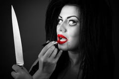 Giovane donna castana che applica rossetto facendo uso del coltello come MIR fotografie stock libere da diritti Giovane donna castana che applica rossetto facendo uso del coltello come MIR fotografie stock libere da diritti