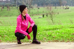 Giovane donna che analizza la pista prima dell'correre un giorno di inverno freddo sulla pista di addestramento di un parco urban fotografie stock Giovane donna che analizza la pista prima dell'correre un giorno di inverno freddo sulla pista di addestramento di un parco urban fotografie stock