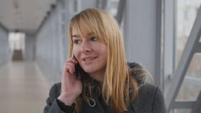 Giovane donna che parla sul telefono e sulla passeggiata nel giorno dell'interno Ritratto della ragazza attraente che parla sul c video d archivio Giovane donna che parla sul telefono e sulla passeggiata nel giorno dell'interno Ritratto della ragazza attraente che parla sul c video d archivio