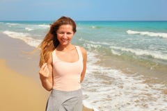 Giovane donna che è strabico un occhio, come il forte sole splende su lei alla spiaggia, mare nel fondo fotografie stock libere da diritti Giovane donna che è strabico un occhio, come il forte sole splende su lei alla spiaggia, mare nel fondo fotografie stock libere da diritti