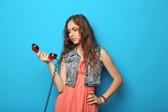 Giovane donna con il telefono rosso fotografia stock Giovane donna con il telefono rosso fotografia stock