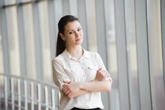 Giovane donna di affari che parla sul telefono cellulare mentre facendo una pausa finestra in ufficio Bello giovane modello femmi fotografia stock Giovane donna di affari che parla sul telefono cellulare mentre facendo una pausa finestra in ufficio Bello giovane modello femmi fotografia stock