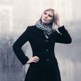 Giovane donna di modo in cappotto nero che cammina in una nebbia all'aperto fotografia stock libera da diritti Giovane donna di modo in cappotto nero che cammina in una nebbia all'aperto fotografia stock libera da diritti