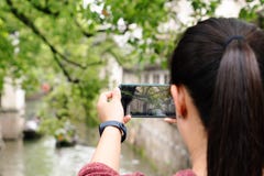 Giovane donna divertendosi nella citt? locale del canale in Cina con la macchina fotografica sullo smartphone che fa le immagini immagine stock Giovane donna divertendosi nella citt? locale del canale in Cina con la macchina fotografica sullo smartphone che fa le immagini immagine stock