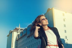 Giovane donna felice che cammina su una via della città fotografia stock Giovane donna felice che cammina su una via della città fotografia stock